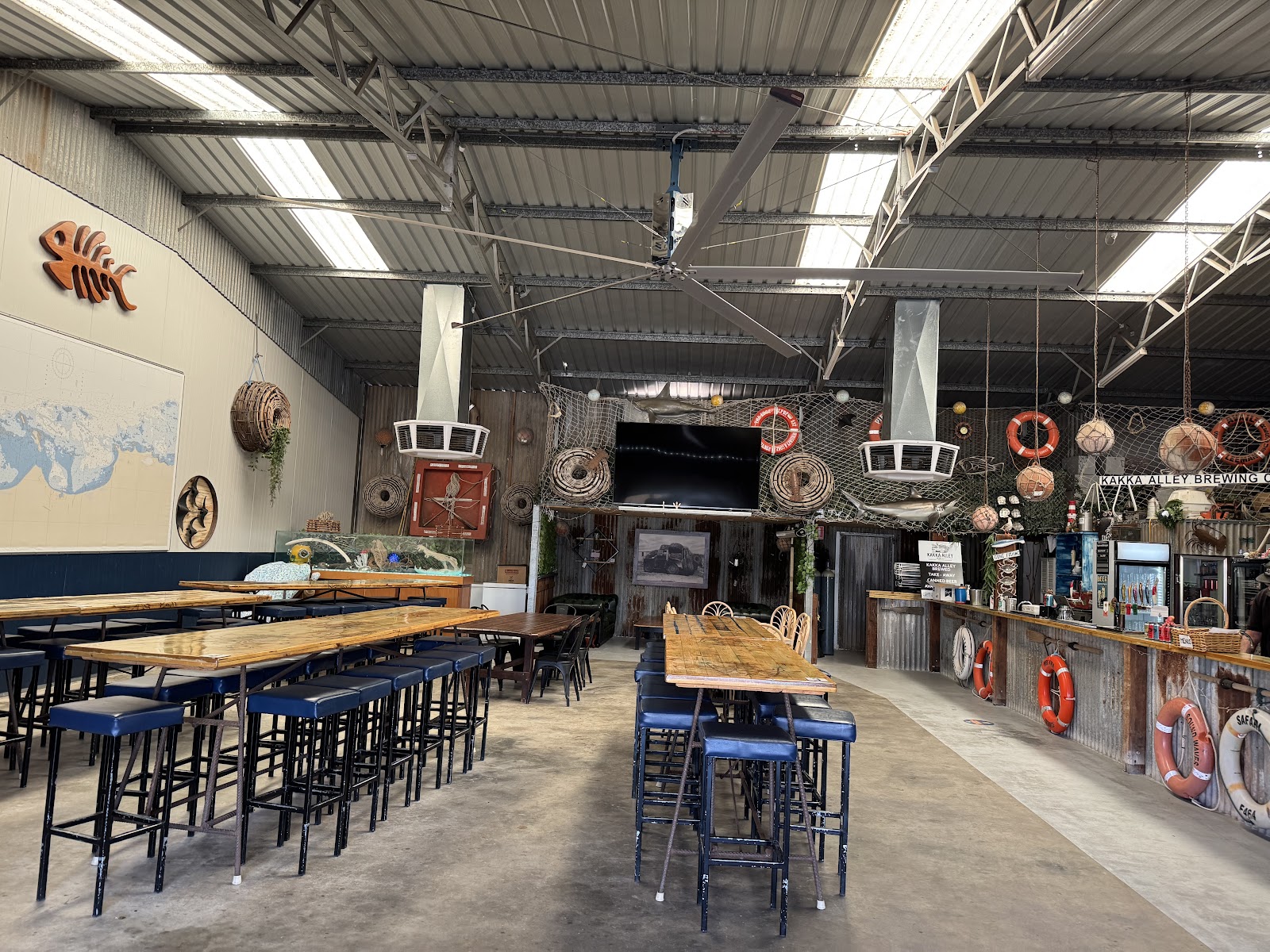 Inside the brewery shed: long high tables, nautical decor and the bar at the far end